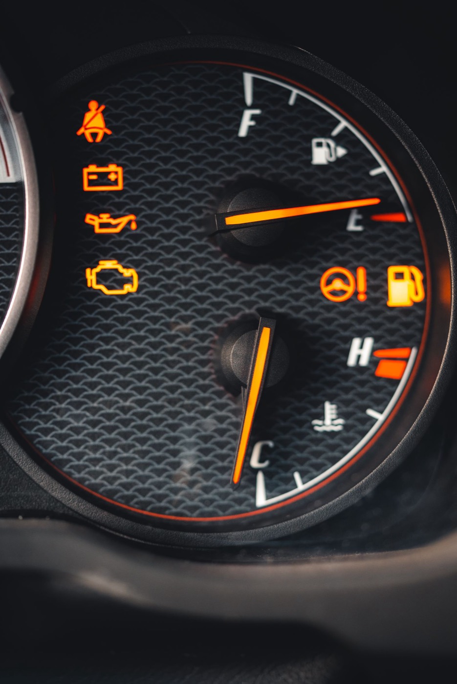 A car dashboard with several warning lights lit up, including the engine and battery symbols