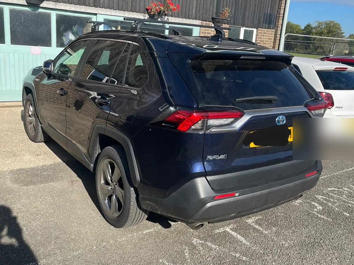 A dark blue Toyota RAV4 parked in a car park, seen from behind, before the work started
