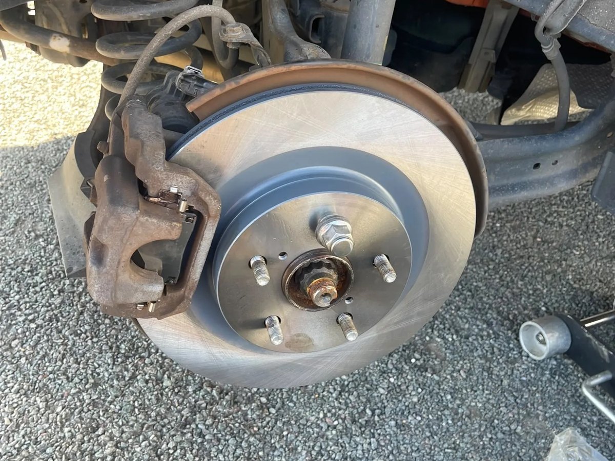 Another new brake disc fitted, with the suspension spring and the caliper carrier visible behind