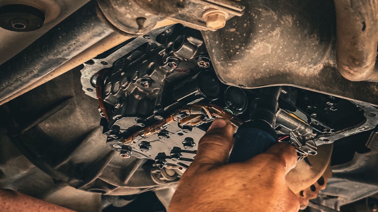 Mechanic inspecting a timing belt and pulleys inside a car engine