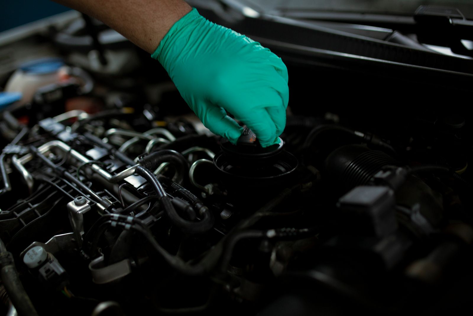 Mobile mechanic checking a car engine under the bonnet