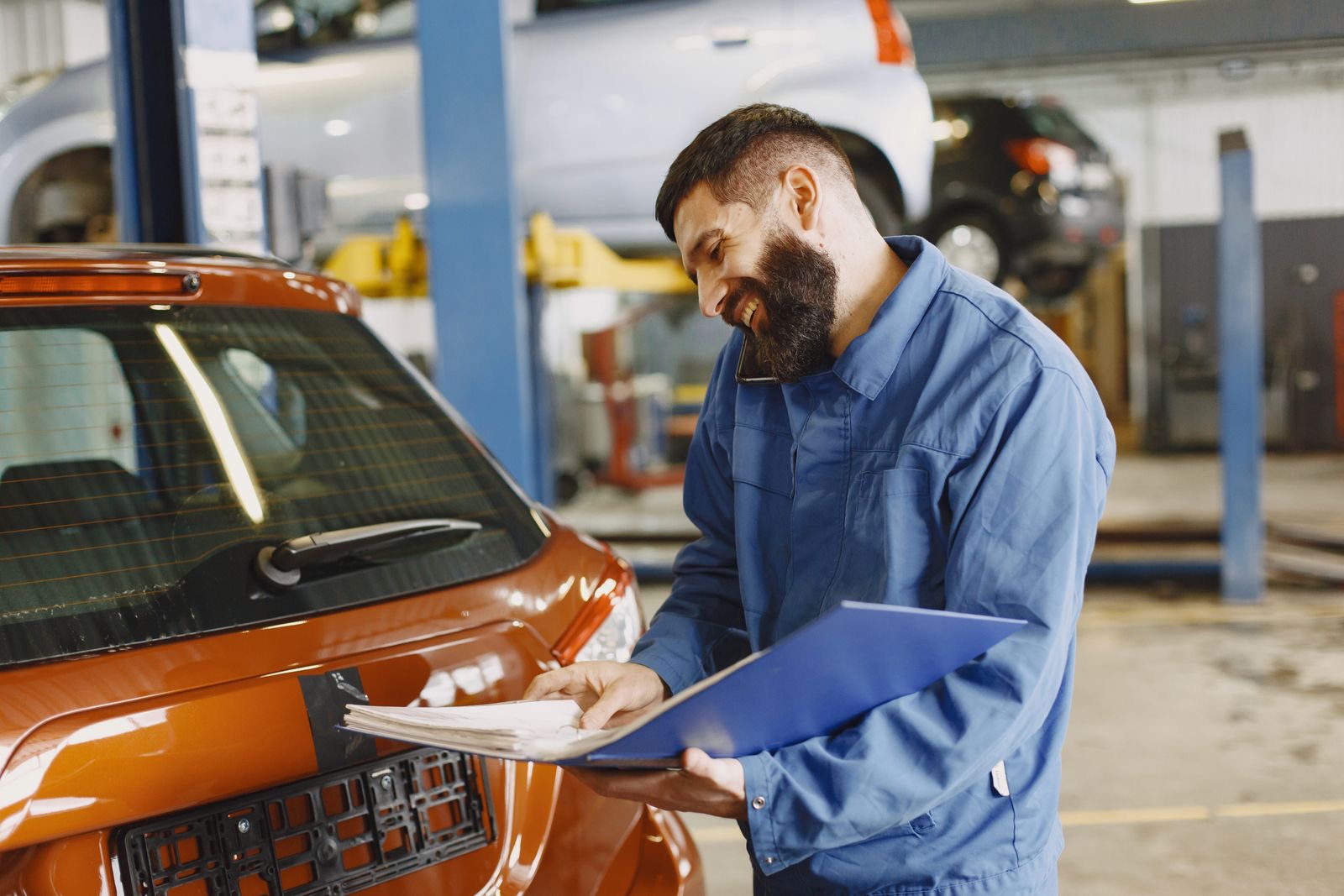 Mobile mechanic inspecting a car's brakes and lights before an MOT on a driveway